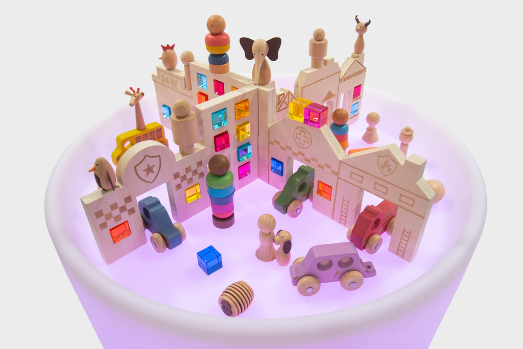 Close view of Discovery Town play table showing tiny buildings, cars, and people figures