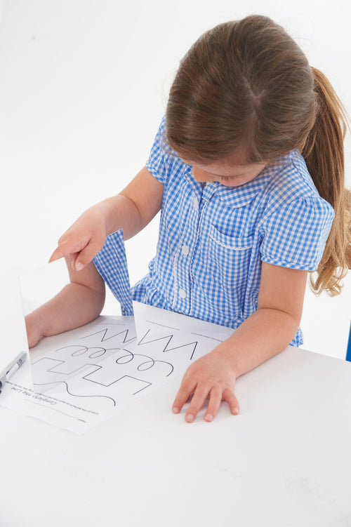 Rectangular double-sided mirror board; child’s hand rests beside marker drawing