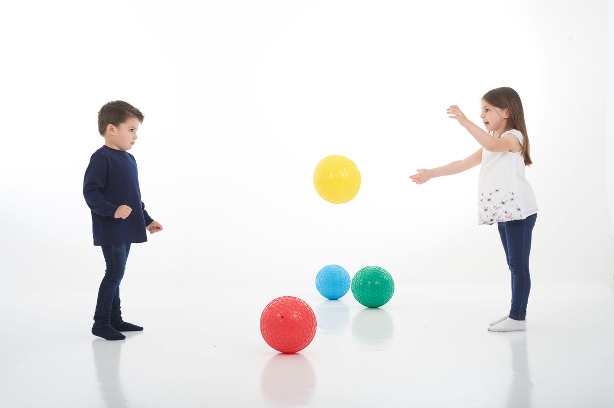 Four textured grip balls: one yellow in the air with blue, green, and red