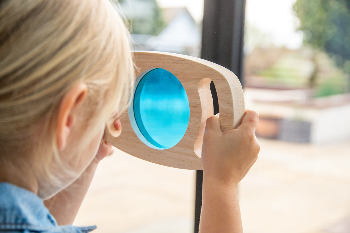 Wooden color panel frame with translucent blue window held near a window