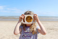 Child holding a wooden sensory face visor with an amber tinted viewing window
