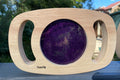 Purple glitter circle panel on light wood frame with hand cutouts