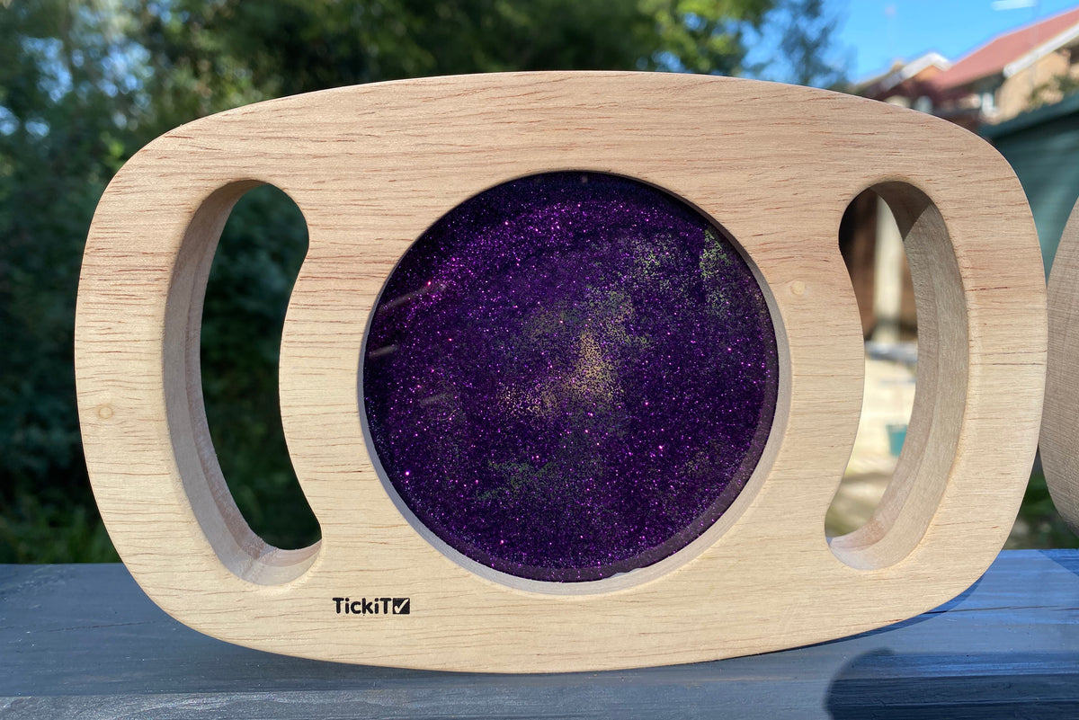 Purple glitter circle panel on light wood frame with hand cutouts