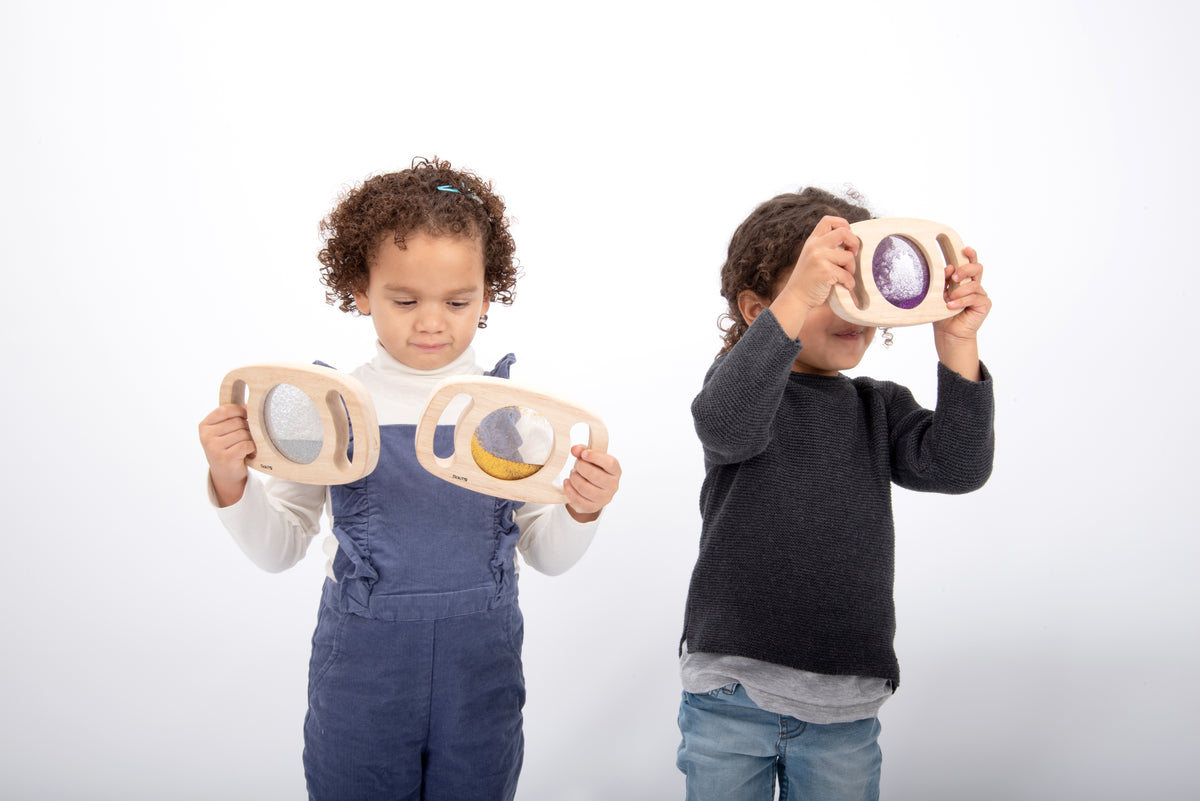Glitter panel set toy with wooden oval frames held by two kids; multiple colorful inserts