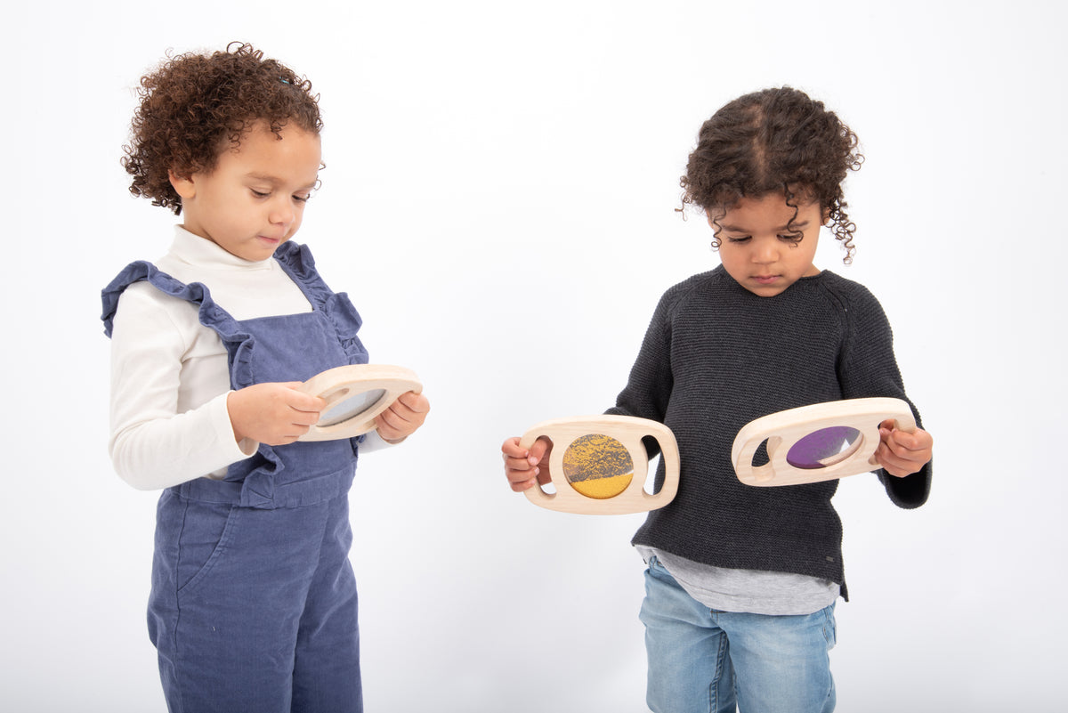 Wood glitter panel set toy with oval frames; kids hold glitter inserts in purple, gray, and gold