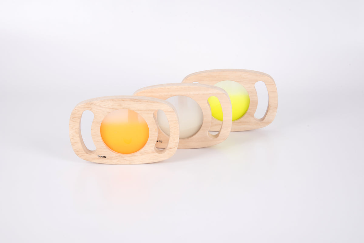 Three wooden glow panels with orange, white, and pale yellow illuminated discs