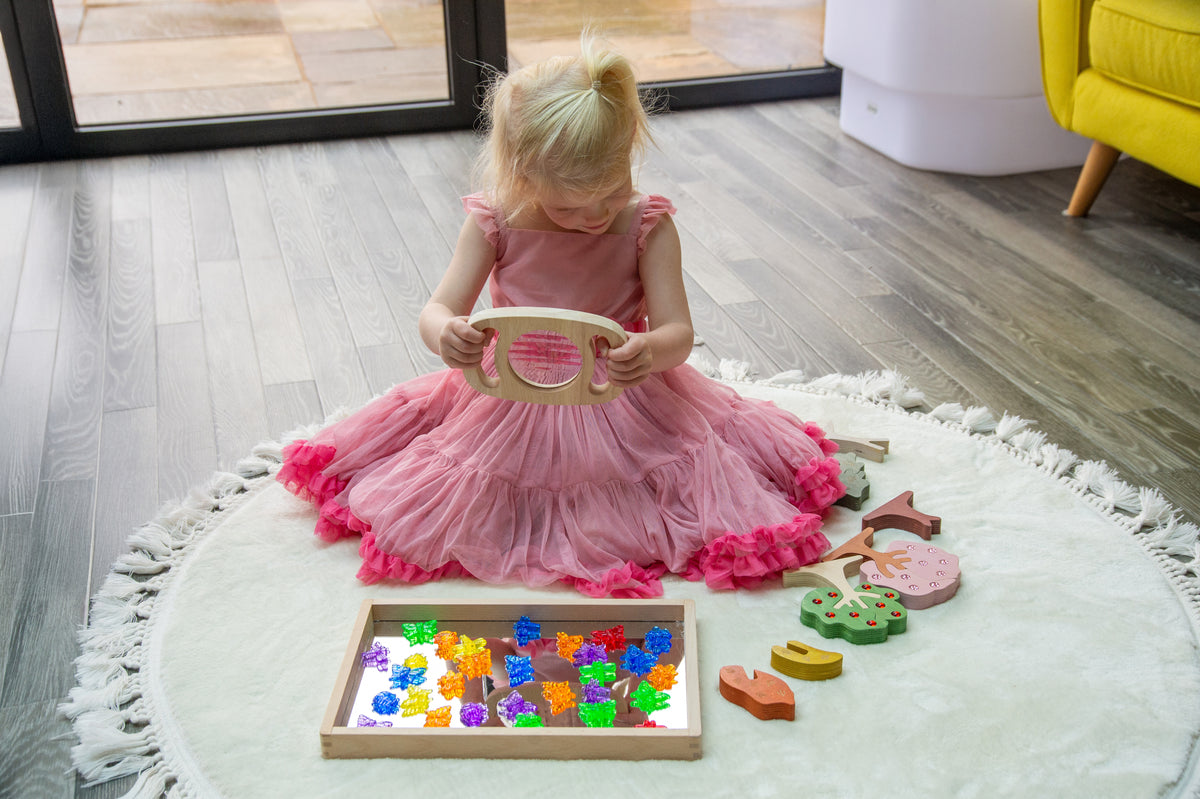 Kids play set with kaleidoscope viewer and colorful wooden pieces on a round rug