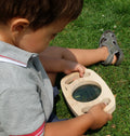 Handheld wooden magnifier with round glass lens, child holding it