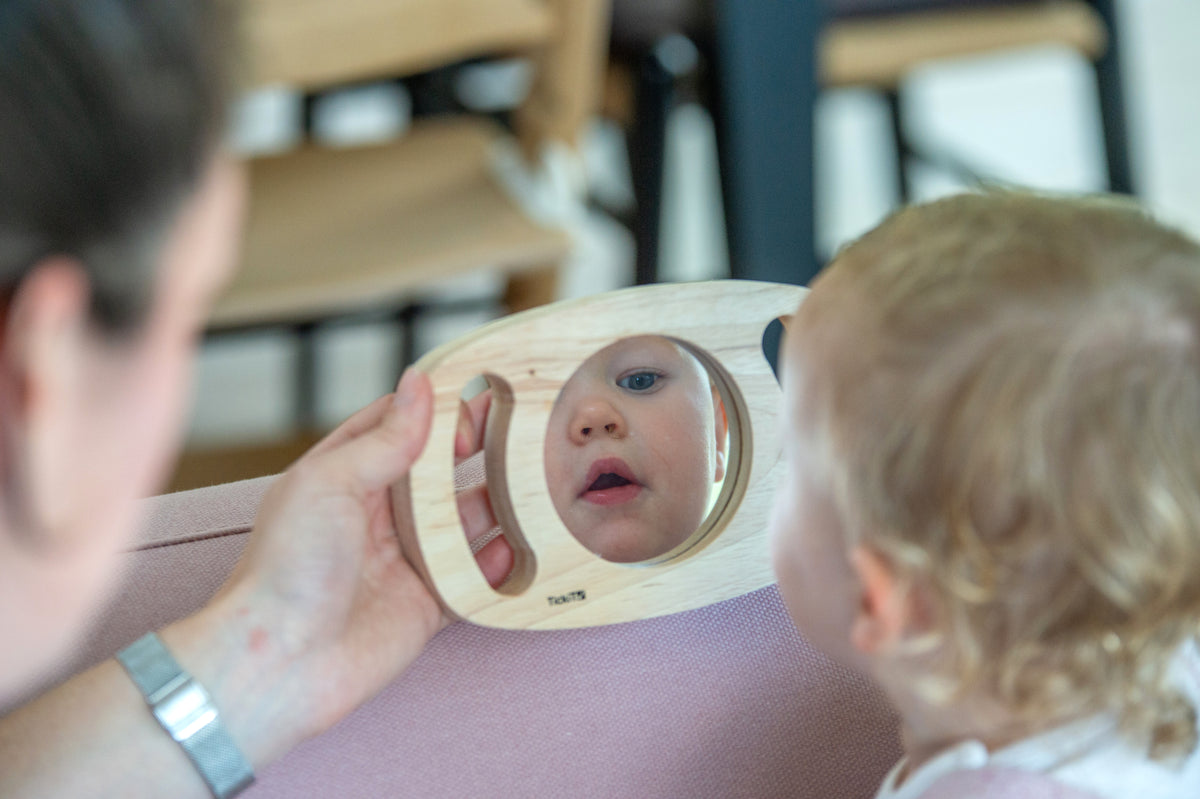 Kids oval wooden mirror with reflective glass, child looking through