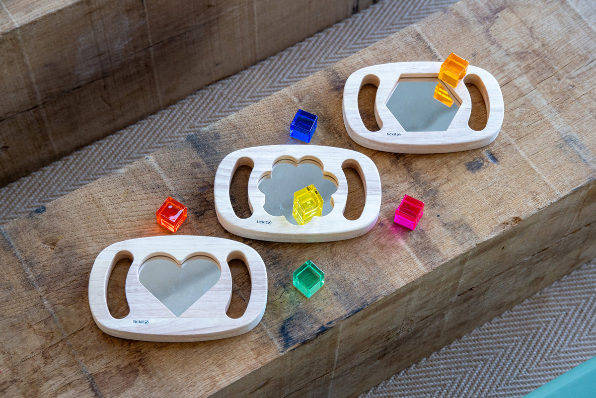 Wooden shape mirrors with heart and octagon frames; colorful pieces scattered nearby