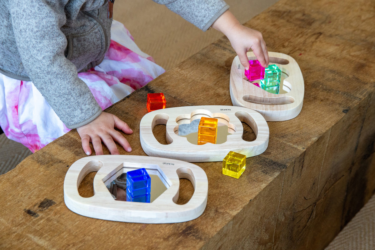 Wooden shape mirror set on floor with heart and hex frames plus colorful blocks