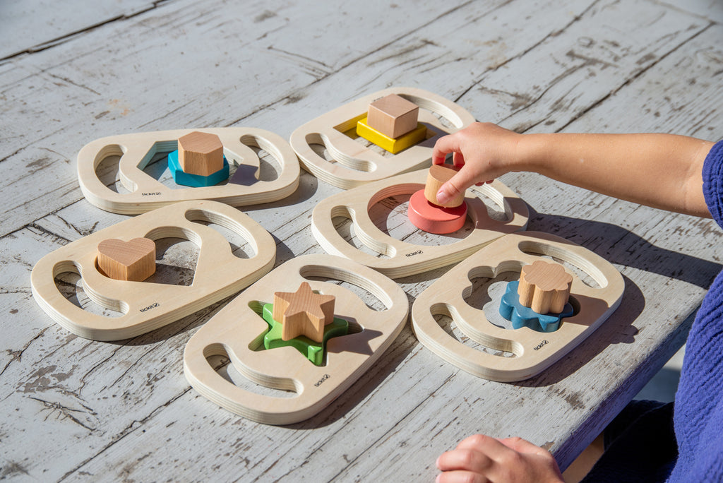 Wooden shape sorter boards with colorful wooden blocks arranged in heart and star slots