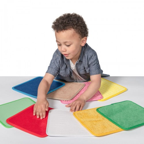 Sensory fabric square mats set in red, blue, green, yellow, and white.