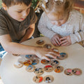 Set of round picture matching cards on table, children playing together
