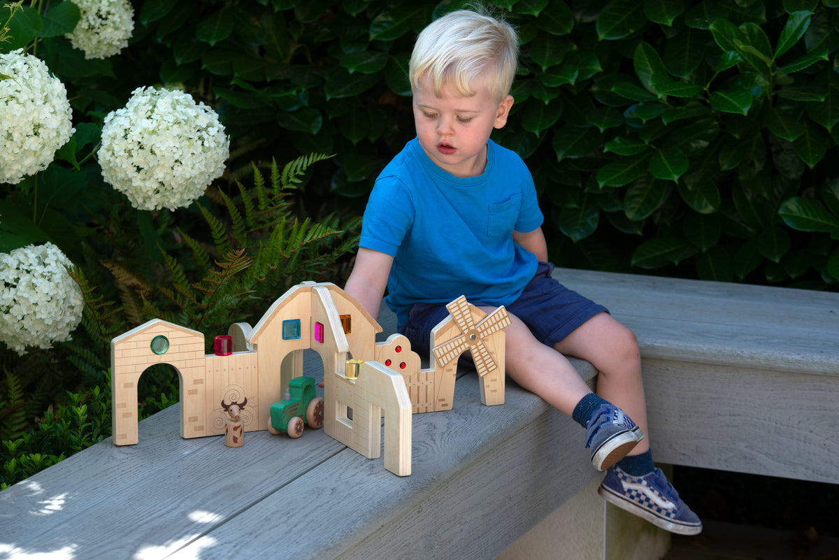 Wooden farm play dividers with child looking at arched rooms and building details