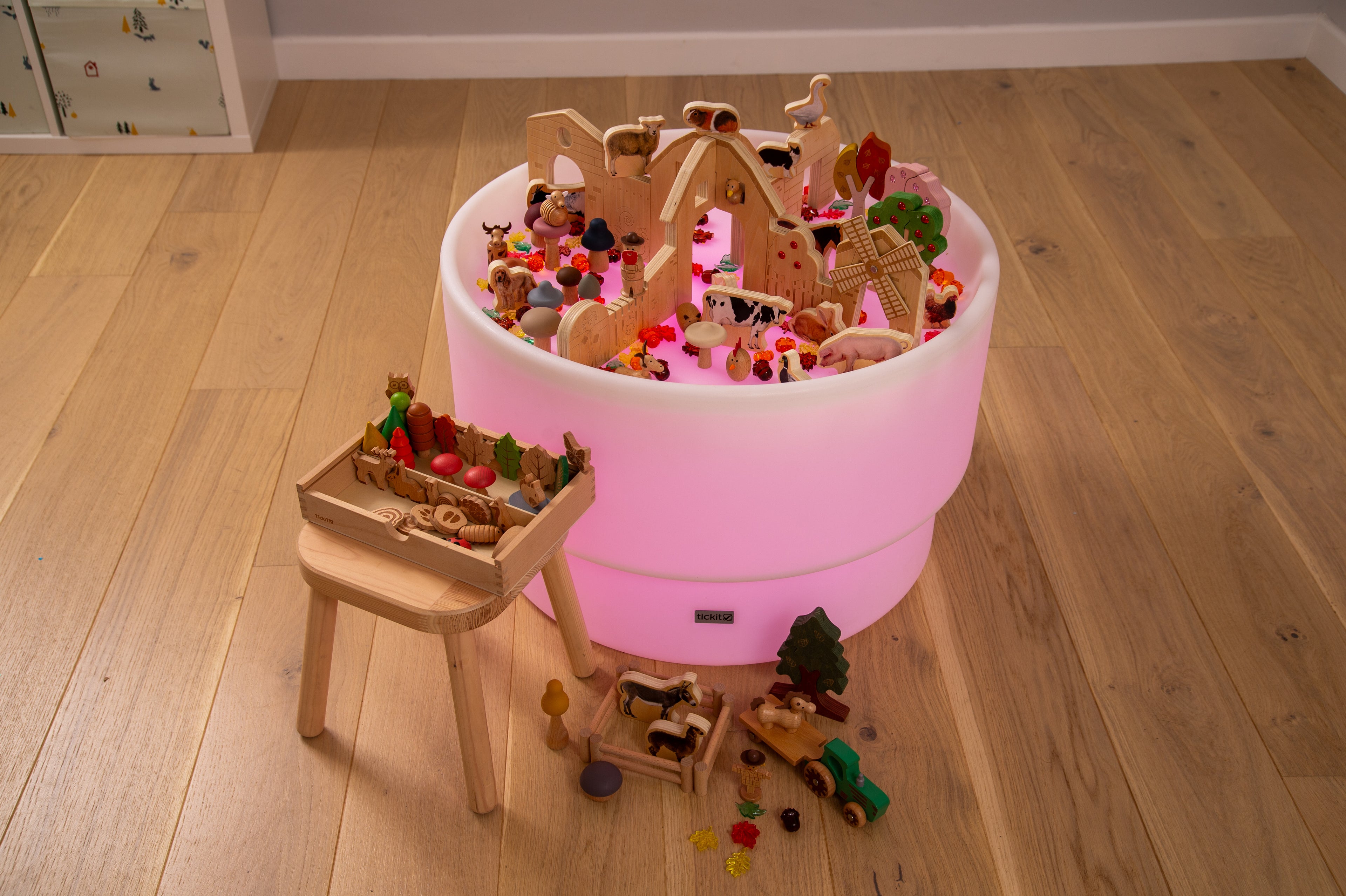 Wooden farm resource toy bundle in a bucket with scattered pieces and a small table.