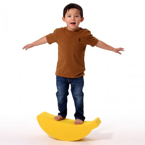 Yellow foam banana balance board with child standing on the curved center