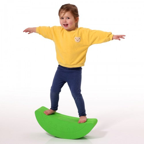 Green foam kiwi balance rocker, half-circle pad for kids, kid standing on top