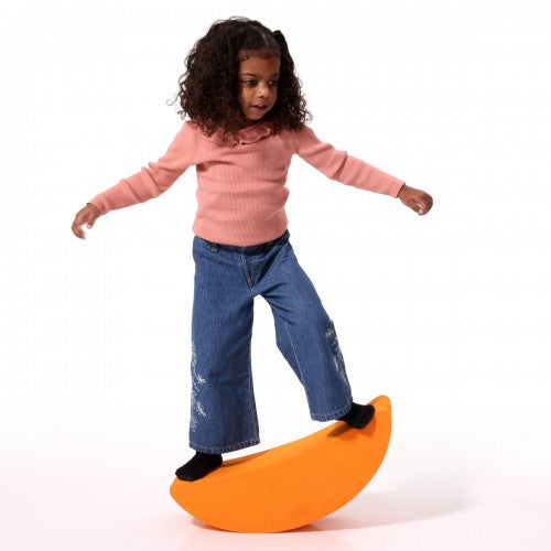 Orange foam fruit rocker with curved semicircle shape, used as a balancing toy