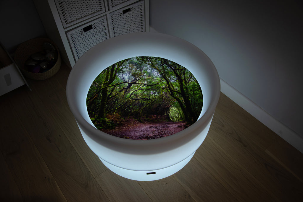 Round forest-themed play mat with glowing rim and forest path insert, dark room lighting