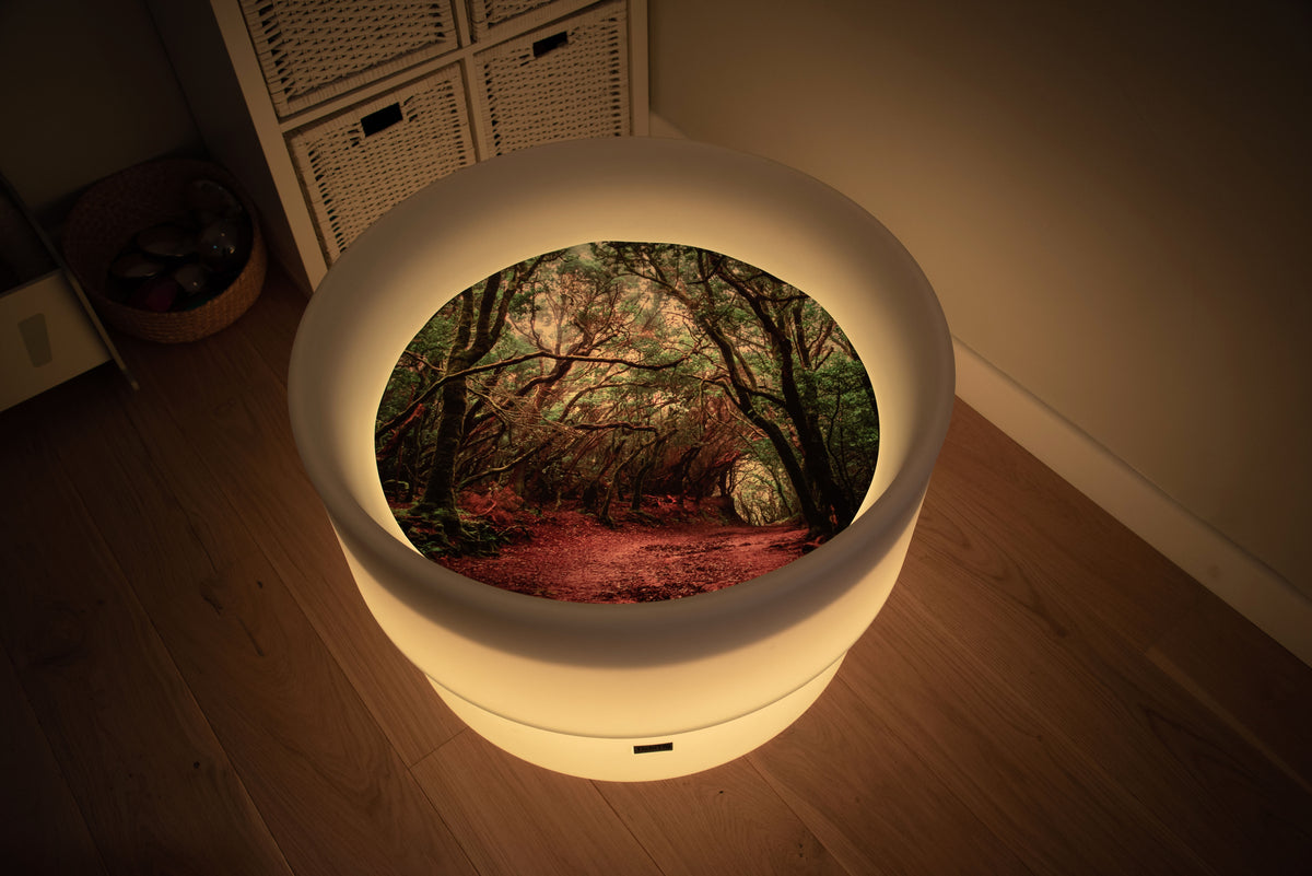 Round forest-themed play mat with glowing rim and forest path insert, warm lighting
