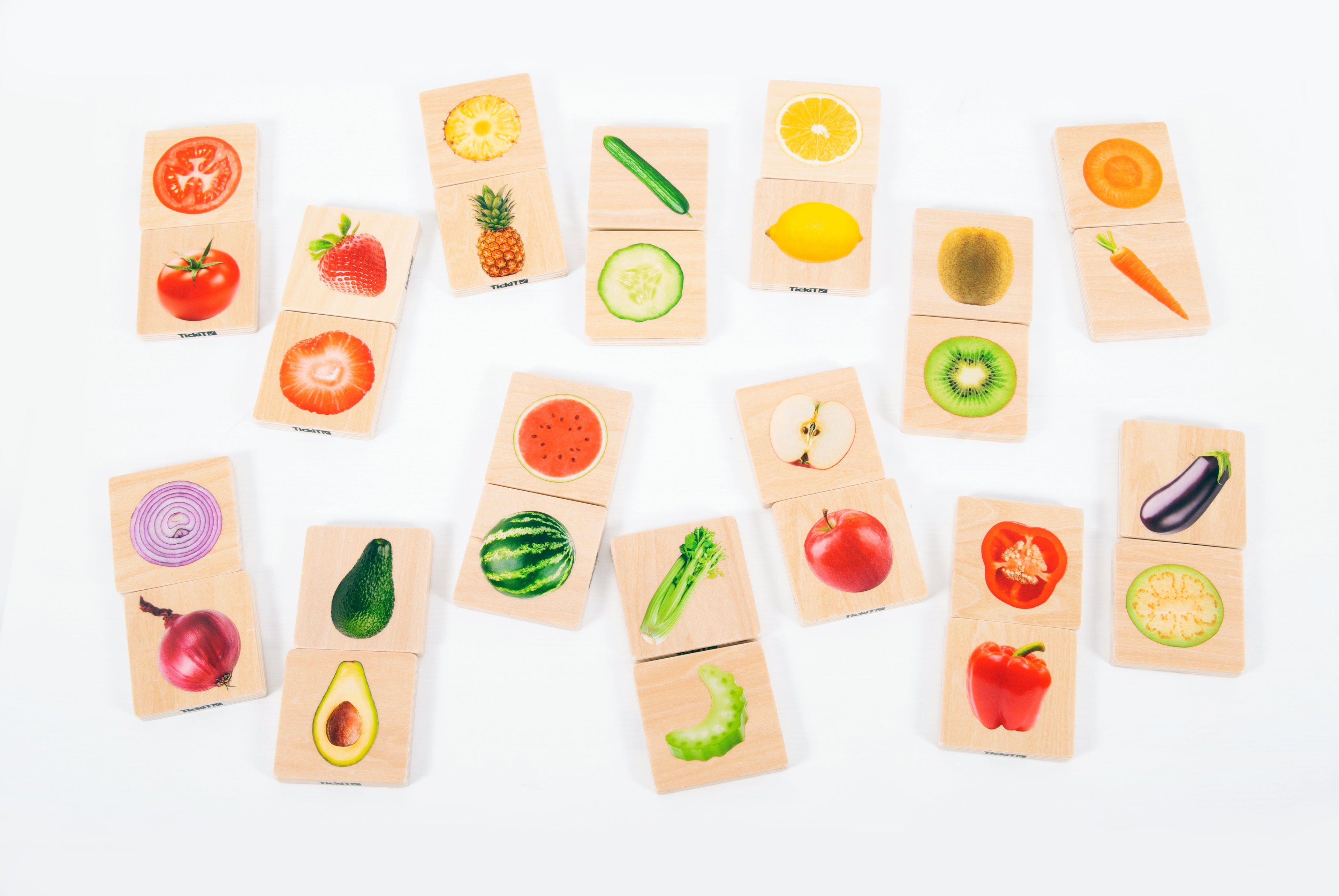 Assorted fruit and vegetable matching cards spread out on a tabletop