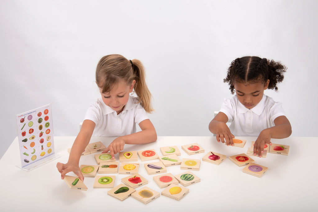 Children playing a fruit and vegetable matching game with picture tiles