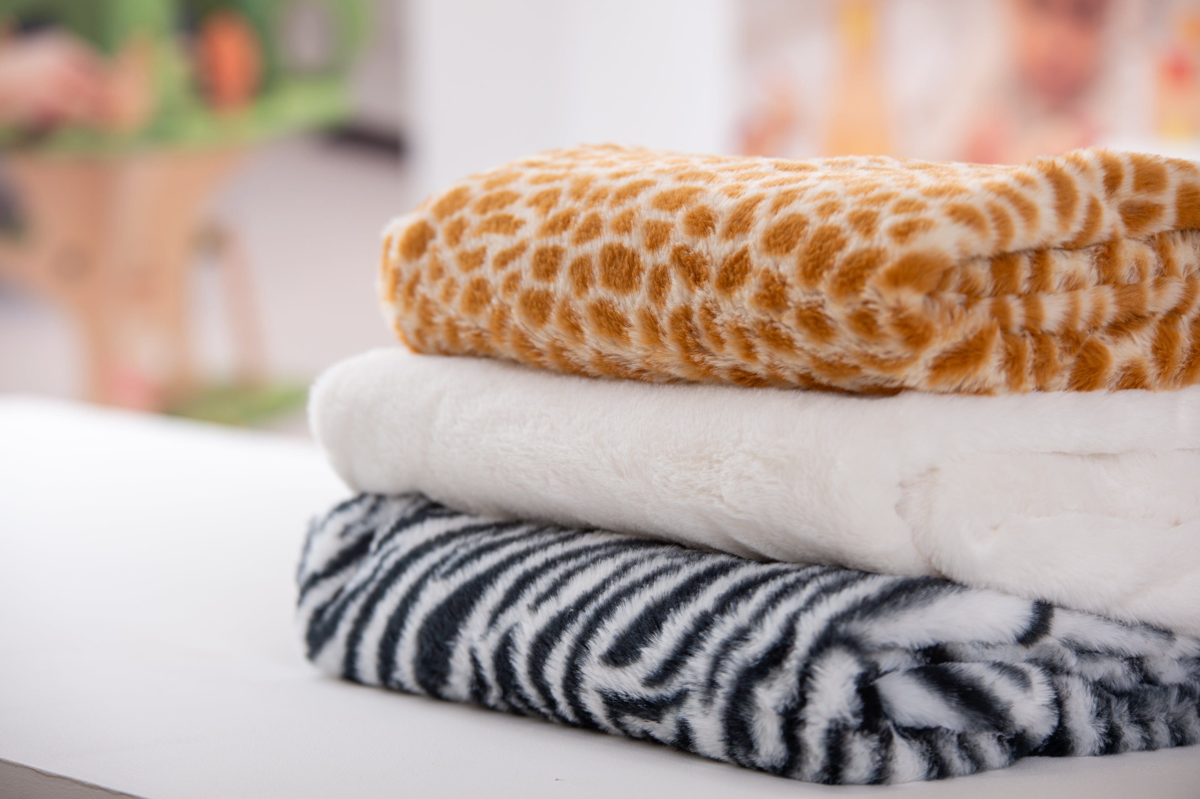 Furry animal print fabric swatches: orange giraffe, white plush, black zebra stripes
