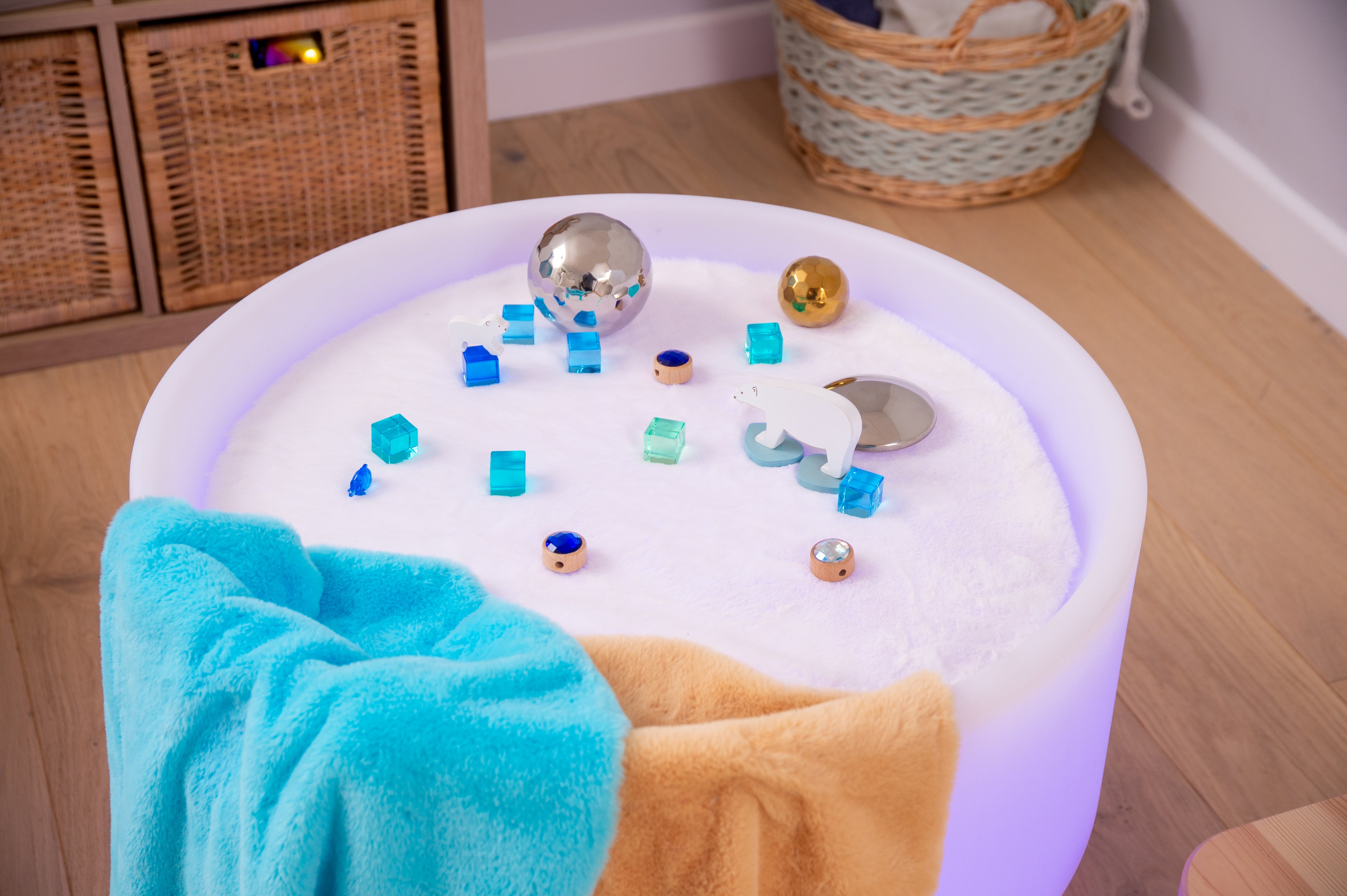 Round sensory play mat with blue textured center, plush sides, and metallic puzzle pieces