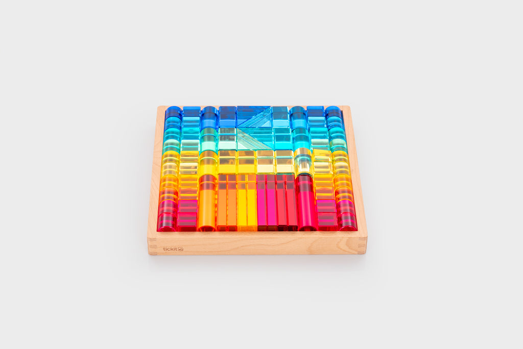 Wooden gem building shapes tray filled with colorful transparent blocks and tubes