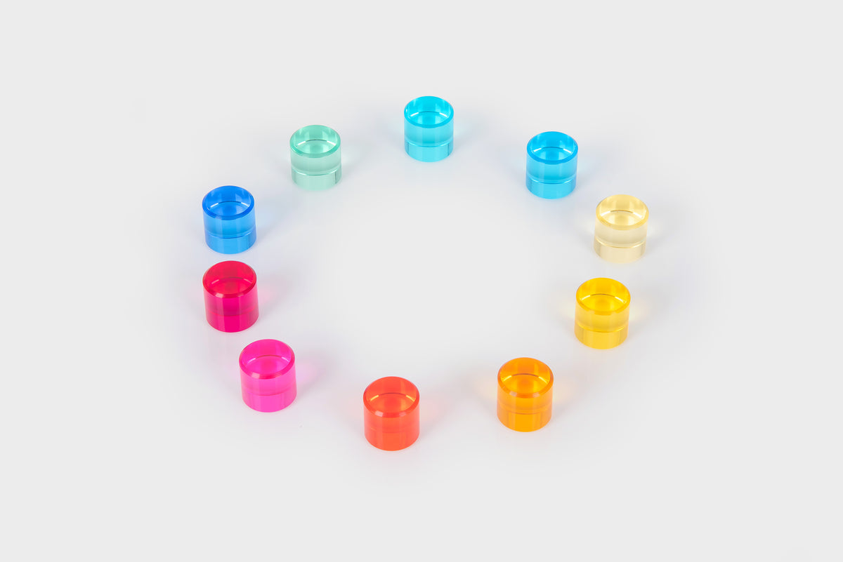 Assorted clear gem cylinders arranged in a ring in blue, teal, orange, and yellow.