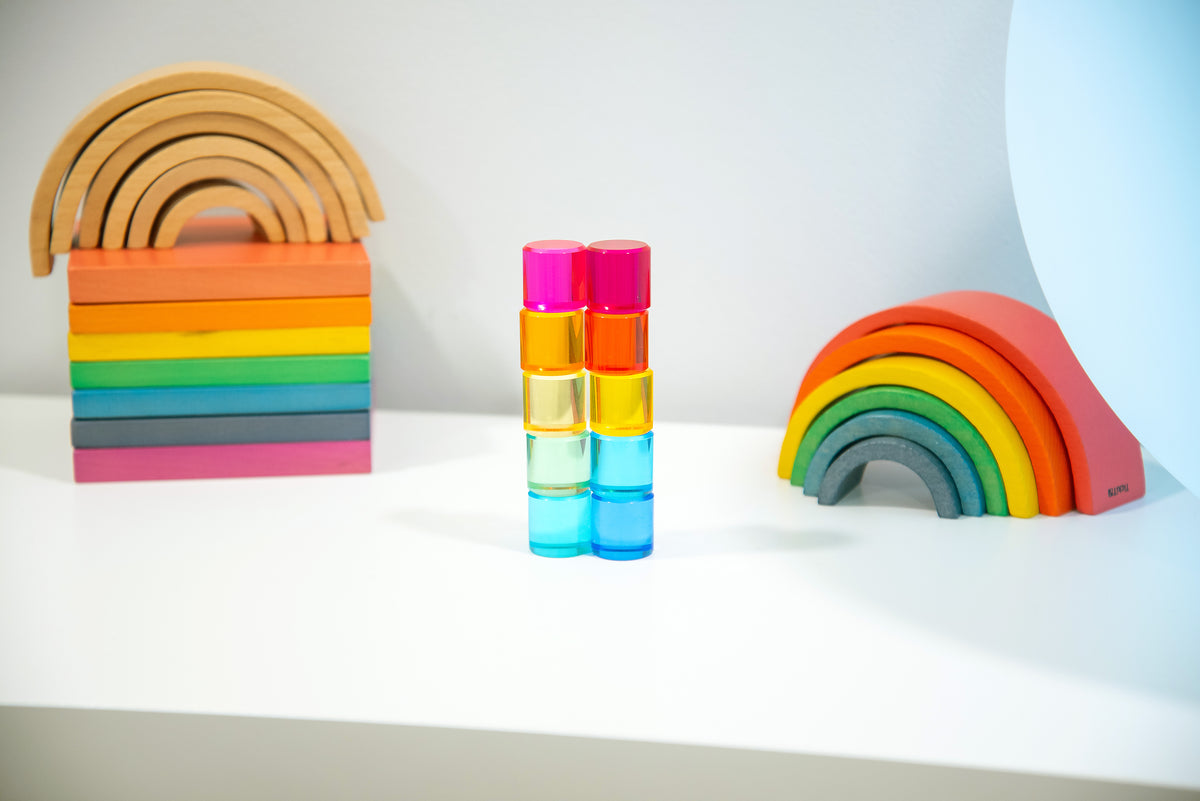 Two-by-two stack of clear gem cylinders in pink, gold, teal, and light blue.