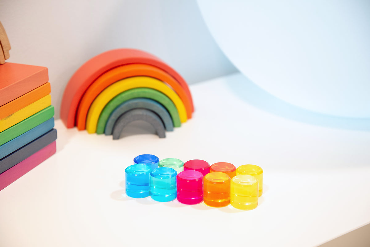 Stack of clear gem cylinders in blue, green, pink, orange, and yellow.