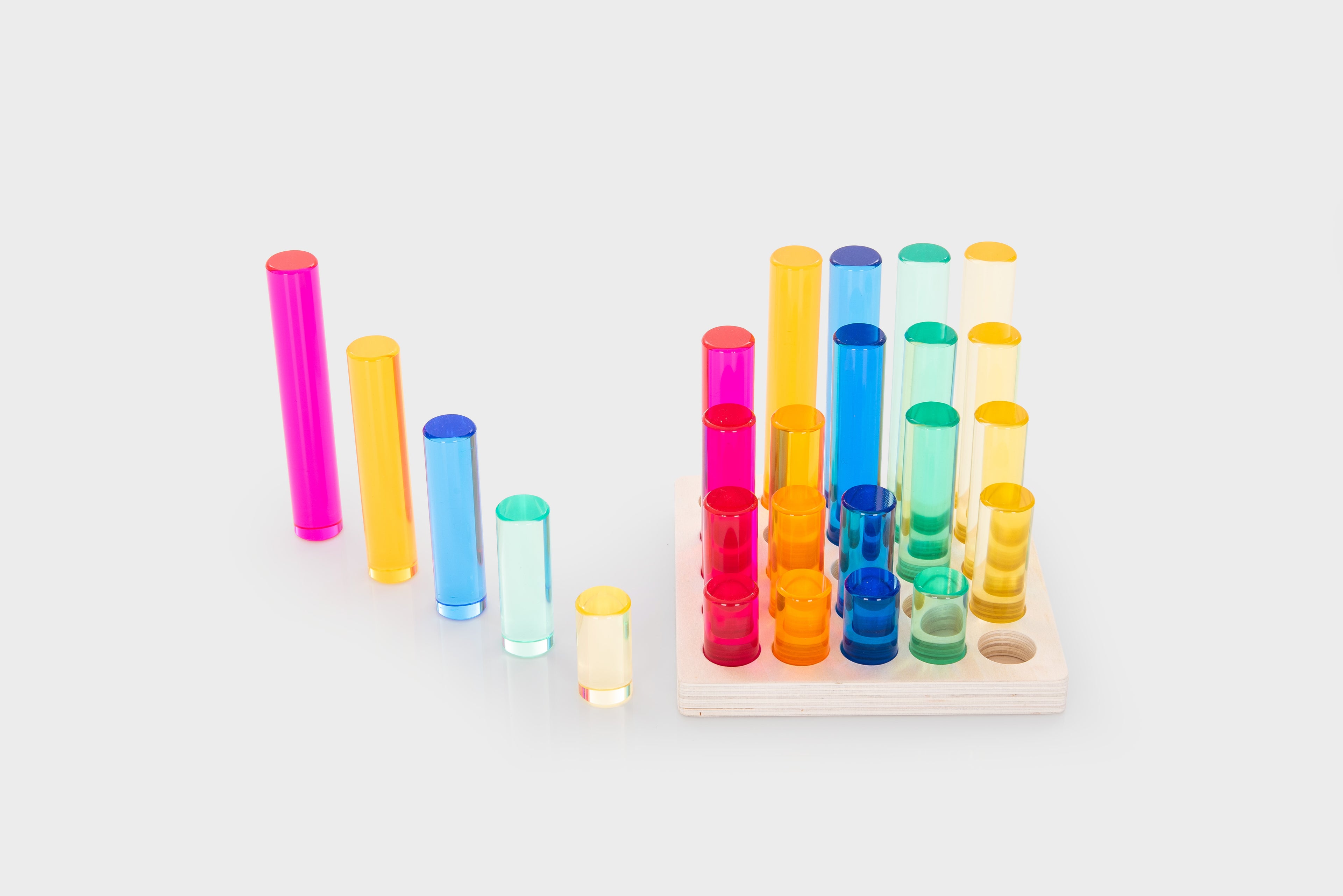Gem column set with multicolor plastic tubes on a light wooden tray and loose columns
