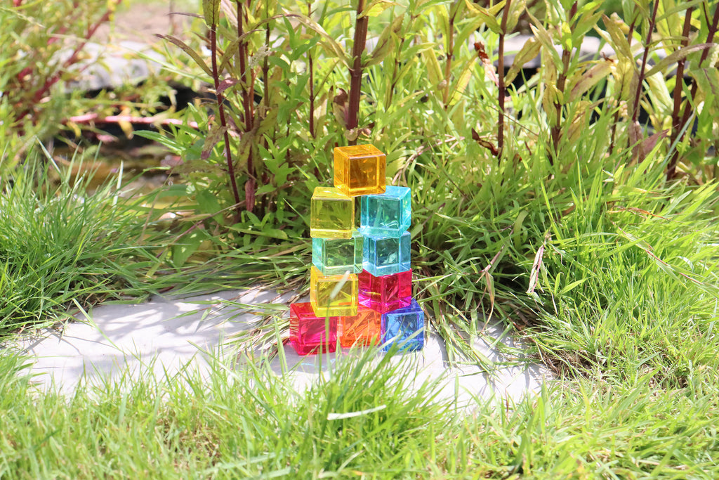Translucent gem cube tower with colorful blocks standing outdoors