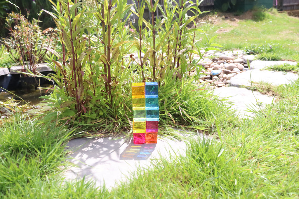 Stacked translucent gem cube blocks standing on a patio in the grass