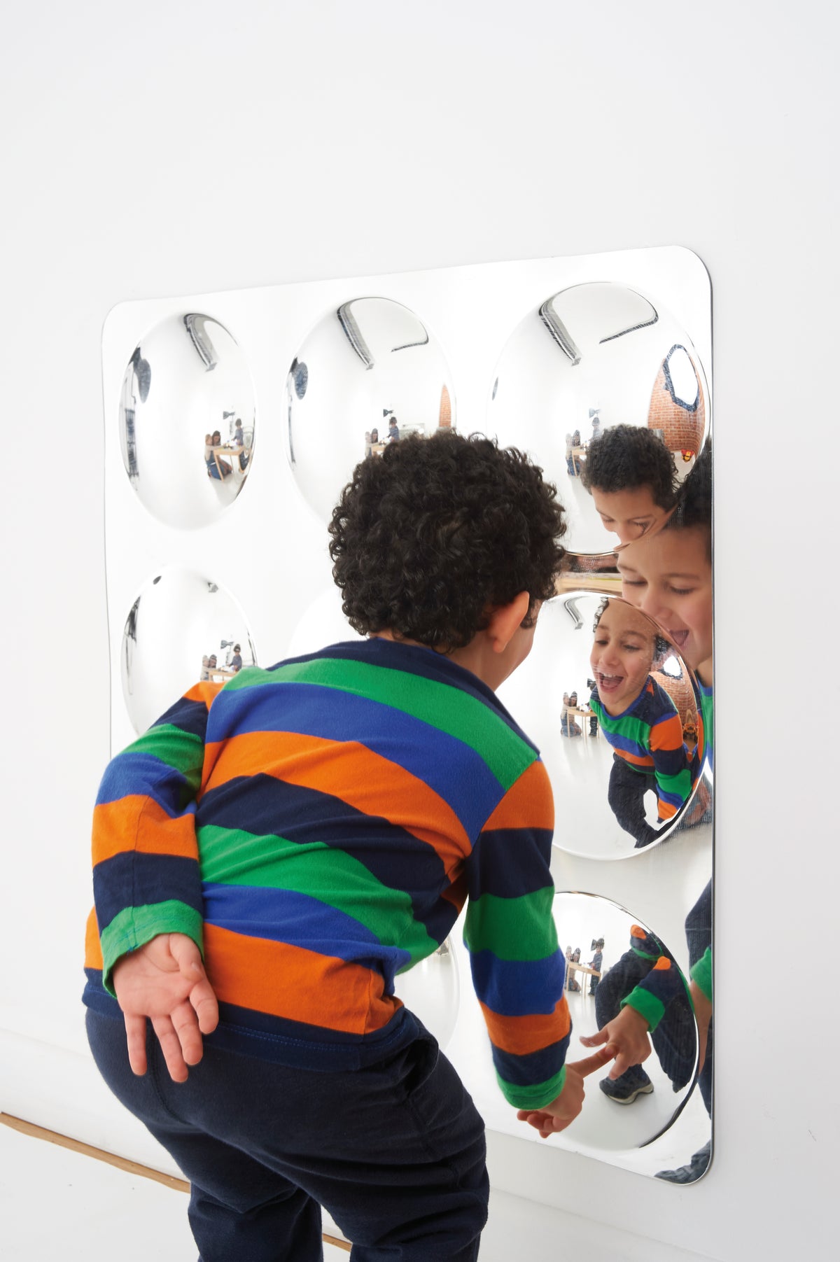 Acrylic 9-dome mirror panel with white frame reflecting children in indoor play
