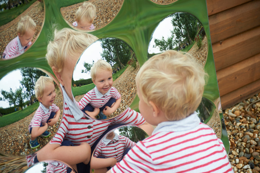 Acrylic 9-dome mirror panel with circular domes reflecting children playing outdoors