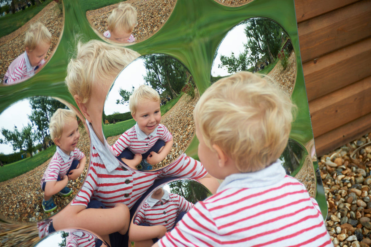 Acrylic 9-dome mirror panel with circular domes reflecting children playing outdoors