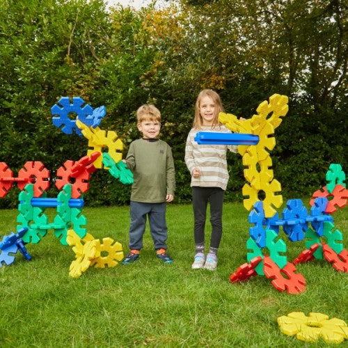 Large colorful foam building gears, held by two kids outdoors, multi-color set