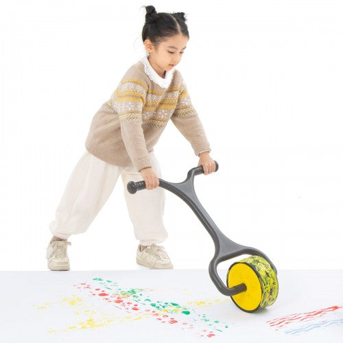Giant paint roller with yellow wheel and gray handle, creating colorful paint streaks