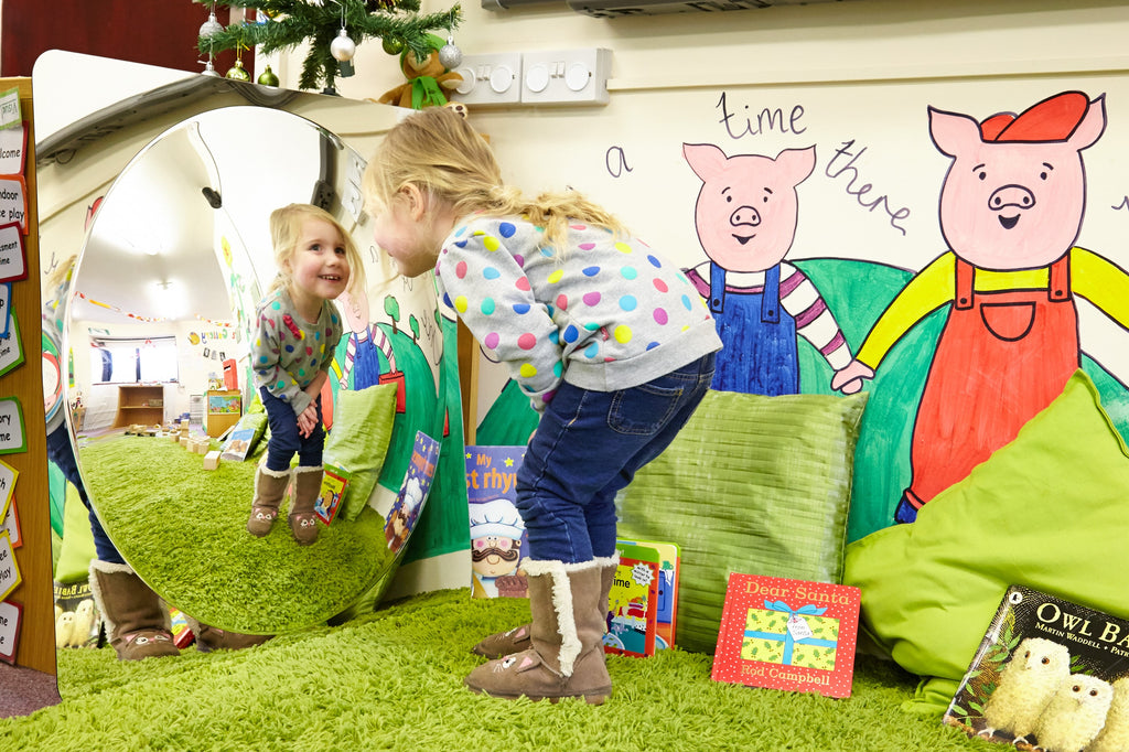 Large acrylic dome mirror panel with rounded reflective opening in a kids play area