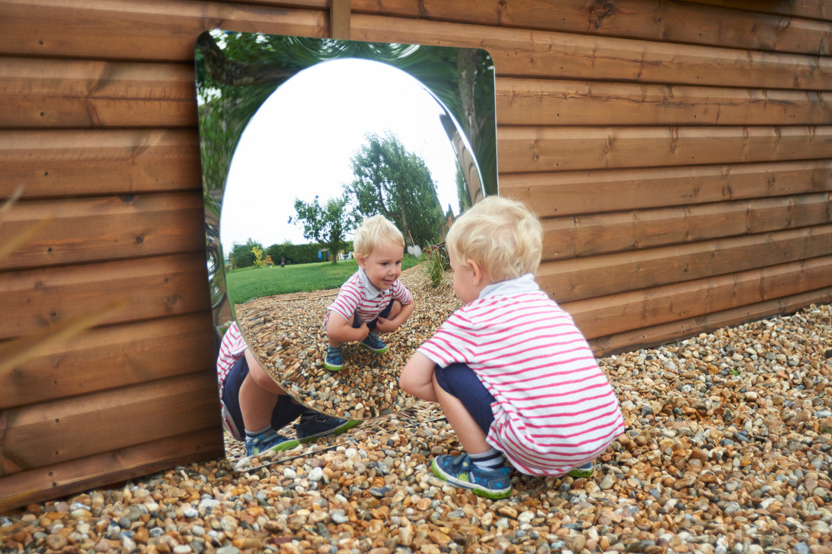 Acrylic dome mirror panel mounted in wooden wall with curved reflective opening