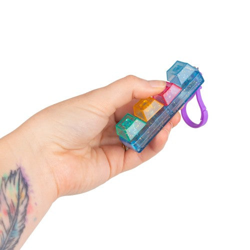 Glitter clicker keychain with blue body, multicolor window blocks, purple wrist loop