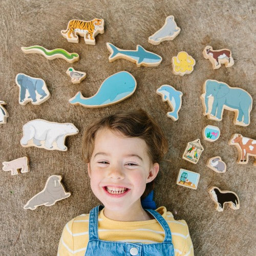 Colorful animal cutout shapes on felt fabric, with a smiling child nearby