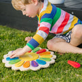 Colorful wooden shape activity puzzle with rounded pieces on grass