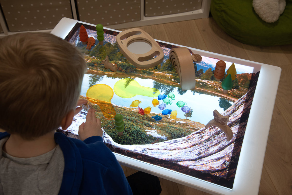 Kids’ play mat with toy pieces on a colorful underwater lake scene