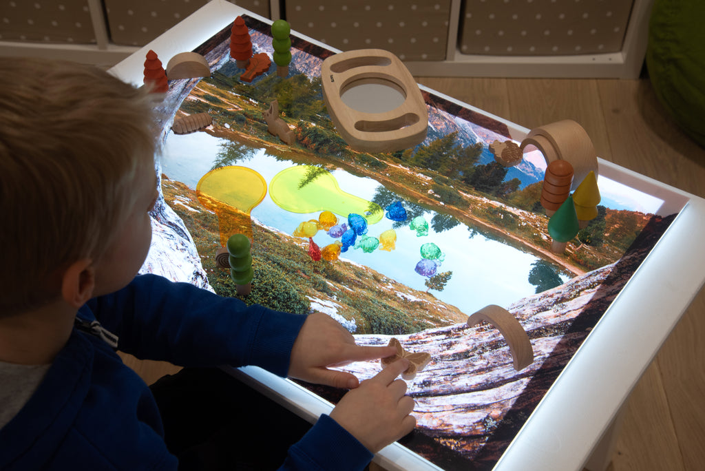Kids’ play mat in use with toys on a colorful lake scene