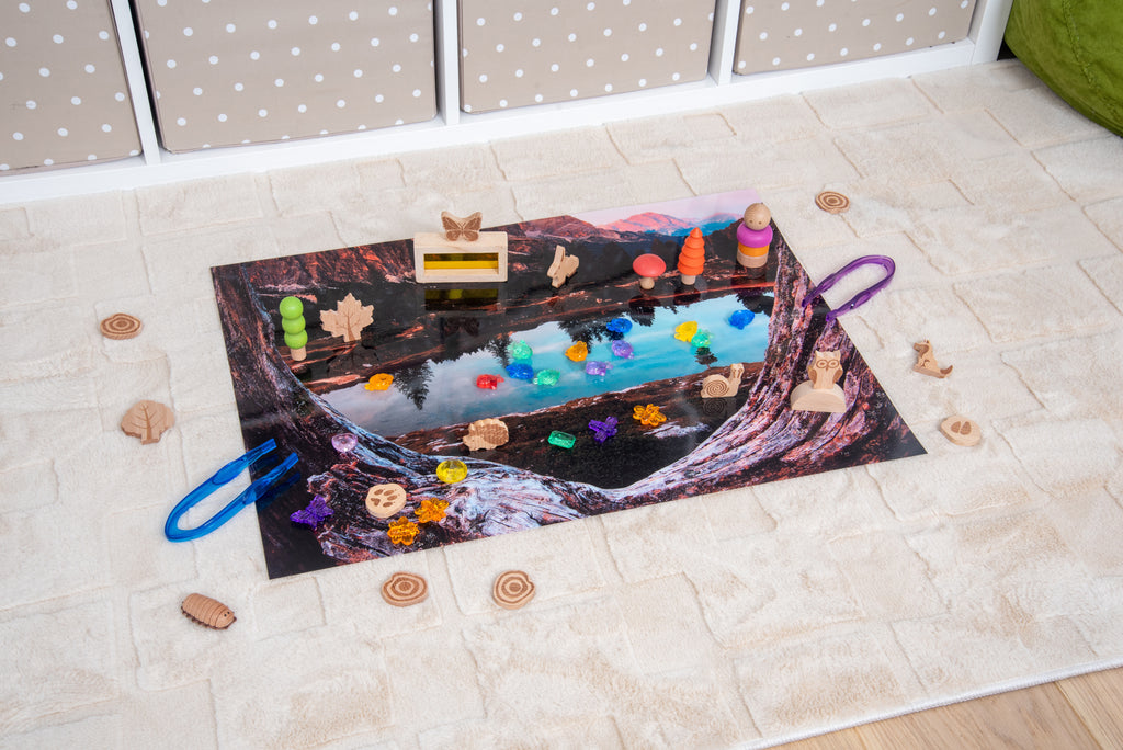 Kids’ play mat with colorful lake scene artwork and toy figures around it