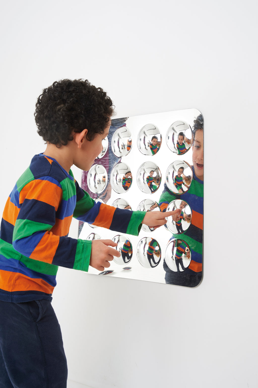 Wall-mounted acrylic mirror panel with 16 domed round mirrors, child touching